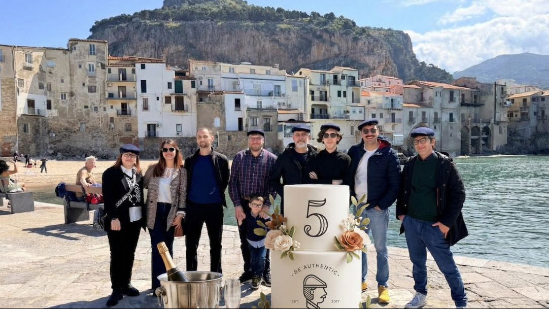 Il team Paesano riunito sul lungomare di Cefalù con la torta celebrativa per i 5 anni del brand